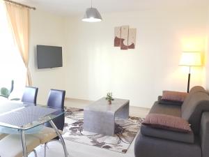 sala de estar con sofá y mesa en Apartamentai "Nadiežda" en Palanga