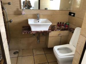 a bathroom with a sink and a toilet at Pinaki Comfort Stay in Mumbai