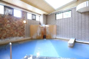 a swimming pool in a room with blue water at Hotel Yudanaka in Yamanouchi