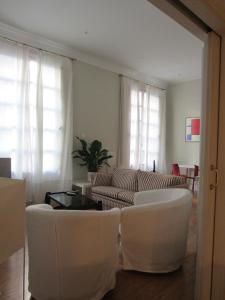 sala de estar con sillas blancas y sofá en Ekain, en Bilbao