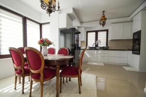 a dining room with a table and chairs and a kitchen at Villa Nad Jeziorem in Kruklanki