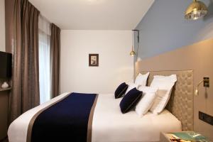 um quarto de hotel com uma cama grande com almofadas em Residhome Bordeaux em Bordéus