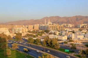 an aerial view of a city with buildings and roads at Muscat Inn Hotel in Muscat