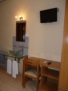 Pokój ze stołem i telewizorem na ścianie w obiekcie Hostal Fernandez w Madrycie