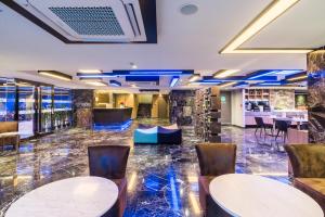 um átrio de um hotel com mesas e cadeiras em Citrus Suites Sukhumvit 6 by Compass Hospitality em Bangkok