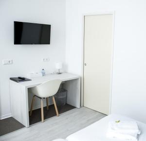 a bathroom with a sink, mirror and a television at City2Beach Hotel in Vlissingen