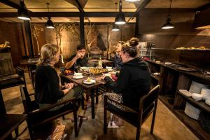 a group of people sitting around a table in a restaurant at BBQ HUB Ella in Ella