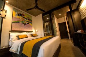 a bedroom with a large bed with a painting on the wall at BBQ HUB Ella in Ella