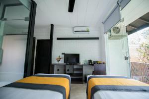 a room with two beds and a tv in it at BBQ HUB Ella in Ella