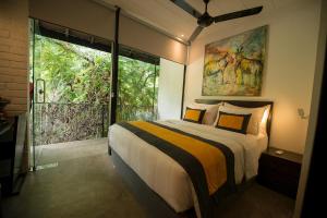 a bedroom with a bed and a large window at BBQ HUB Ella in Ella