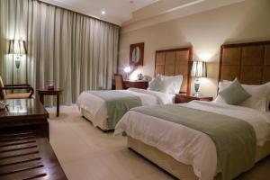 Postel nebo postele na pokoji v ubytování Muscat Inn Hotel