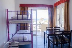 Zimmer mit Etagenbetten und einem Esszimmer mit einem Tisch in der Unterkunft Sofia Apartments SEA VIEW in Georgioupoli