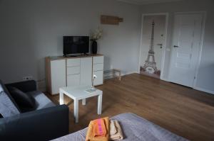 a living room with a couch and a table with the eiffel tower at Apartamenty z klimatem in Poznań