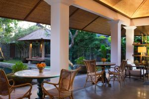 a patio with tables and chairs and a pool at Atelier TE Designer Guesthouse in Sanur