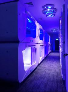 an empty room with purple lights and a corridor at Atlantis Pods @ Little India in Singapore