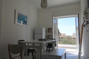 a kitchen with a table and chairs and a window at Colori a mare in Villaggio Azzurro