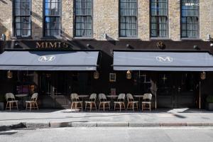 um restaurante com mesas e cadeiras em frente a um edifício em Mimi's Hotel Soho em Londres