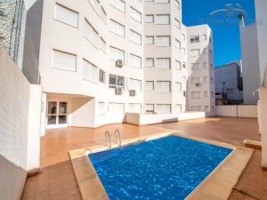 een zwembad voor een gebouw bij At home Residentials in Torrevieja