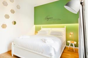 - une chambre avec un lit blanc et un mur vert dans l'établissement Italianway-Passeroni, à Milan