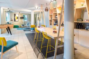 - une cuisine et une salle à manger avec une table et des chaises dans l'établissement Aparthotel Adagio Access Paris Porte De Charenton, à Charenton-le-Pont