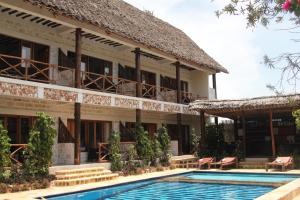 un hotel con piscina frente a un edificio en Tamani Villas - Annex, en Matemwe