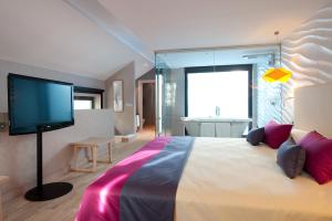 a bedroom with a large bed with a flat screen tv at Vincci Selección Posada del Patio in Málaga