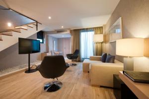 a living room with a couch and a tv in a room at Vincci Selección Posada del Patio in Málaga