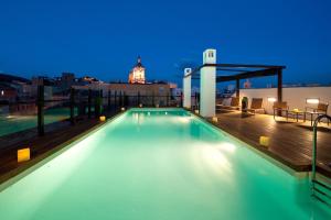 a swimming pool on top of a building at night at Vincci Selección Posada del Patio in Málaga