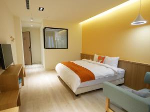 1 dormitorio con 1 cama grande y TV en See Moon Homestay en Yuchi