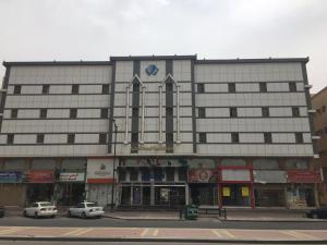 a large building with cars parked in front of it at Al Massah Al Khalijiyah Furnished Units in Dammam