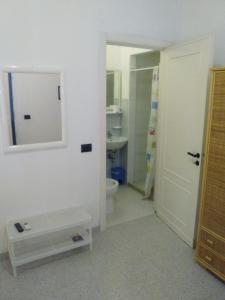 bagno con servizi igienici, lavandino e specchio di Casa Vacanza Fiorella a Torre dell'Orso