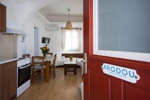 a kitchen and a living room with a table and chairs at Arodou Studio and Apartment in Mikonos