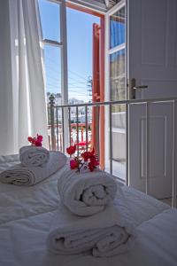 1 dormitorio con 2 toallas en una cama con ventana en Arodou Studio and Apartment, en Mykonos ciudad
