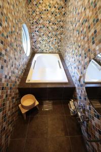a bathroom with a tub and a toilet and a sink at Usaginonedoko in Kyoto