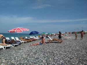 a group of people on a beach with chairs and umbrellas at Orbi Plaza Apartment in Batumi