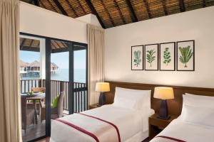 a bedroom with two beds and a balcony at Golden Palm Tree Sepang in Sepang
