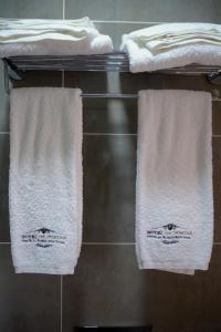 three towels are hanging on a rack in a bathroom at Hotel Os Poetas in Ponte da Barca