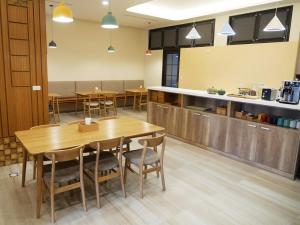 uma sala de jantar com mesas e uma cozinha em See Moon Homestay em Yuchi