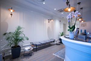 a waiting room with benches and plants in a store at Hotel Majestic in Budva