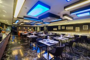 a restaurant with tables and chairs and a bar at Citrus Suites Sukhumvit 6 by Compass Hospitality in Bangkok