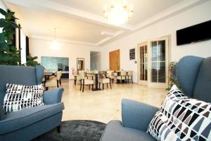 a living room with blue chairs and a dining room at Novitel Hotel Kirchheim - München Messe in Kirchheim