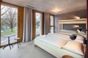 a bedroom with a large bed and a desk and windows at Bern Youth Hostel in Bern