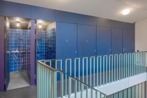 a bathroom with a blue wall and a shower at Bern Youth Hostel in Bern