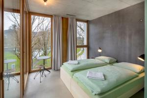 a bedroom with a large bed and a large window at Bern Youth Hostel in Bern