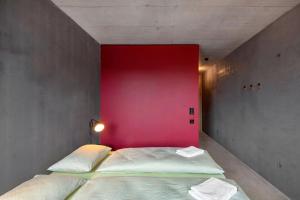 a bedroom with two beds with a pink wall at Bern Youth Hostel in Bern
