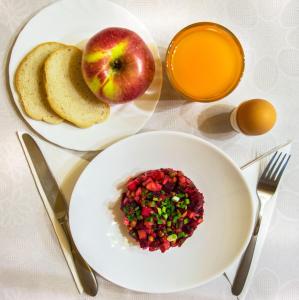 una mesa con dos platos de comida y una manzana y una tostada en Villa Iris, en Yaremche