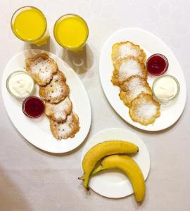 two plates of food with a banana on a table at Villa Iris in Yaremche