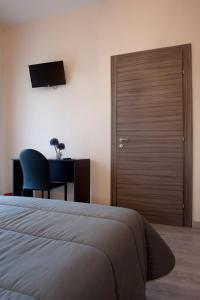 a bedroom with a bed and a desk and a television at Asaro Camere in Campobello di Licata