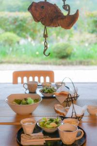 una mesa con tazones de comida y decoración de pescado en Kamakurayama Farm - B&B Satoyama, en Uda