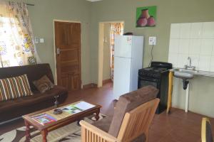 a living room with a couch and a refrigerator at Mount Hermon Safari Cottages in Chaledzela